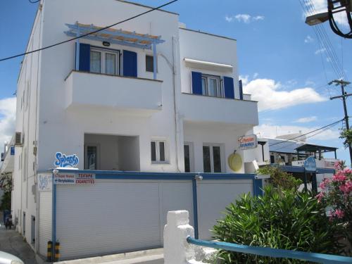 a white house with blue windows and a garage at Pension Verykokkos in Naxos Chora