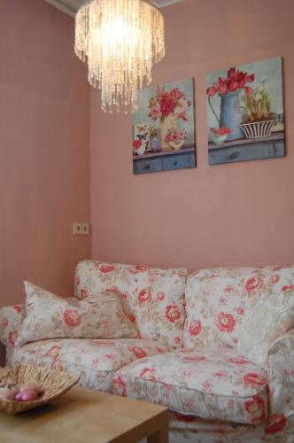 a living room with a couch and a chandelier at Hofgassl Zentgraf in Mörbisch am See