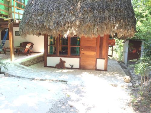 a dog sitting in front of a small hut at Posada del Cerro in El Remate