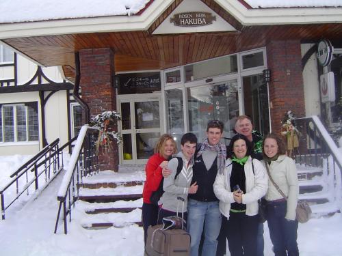 a family posing for a picture in front of a ski lodge at Rosenheim Hakuba in Hakuba