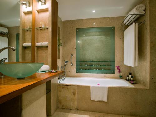 a bathroom with a large tub and a sink at The Lalit Mumbai-Airport in Mumbai