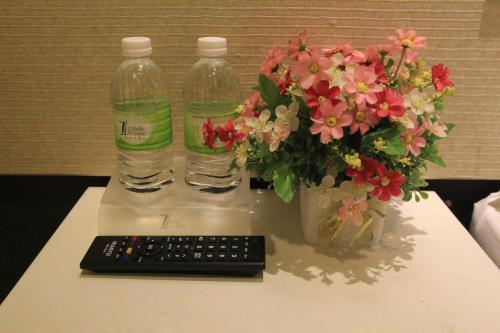 dos botellas de agua y un teclado y flores en una mesa en Putra One Avenue Hotel, en Seri Kembangan