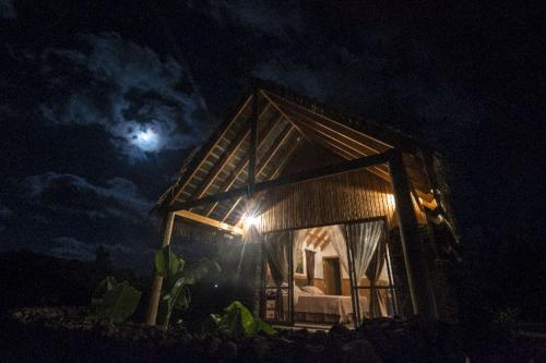 a house at night with the moon in the background at Pacific Bungalows in Hanga Roa