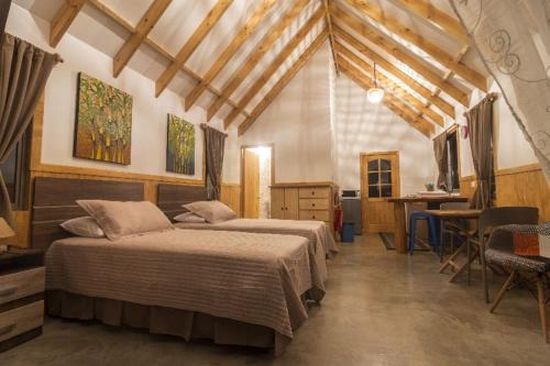 Un dormitorio con 2 camas y un escritorio en una habitación. en Pacific Bungalows, en Hanga Roa