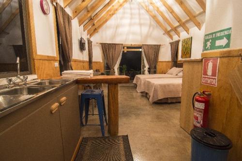 eine Küche mit einem Waschbecken und ein Bett in einem Zimmer in der Unterkunft Pacific Bungalows in Hanga Roa