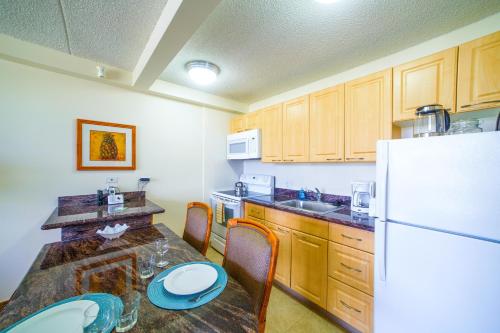 a kitchen with a table and a white refrigerator at Mountain View Condo, Near Beach, Free Parking! in Honolulu
