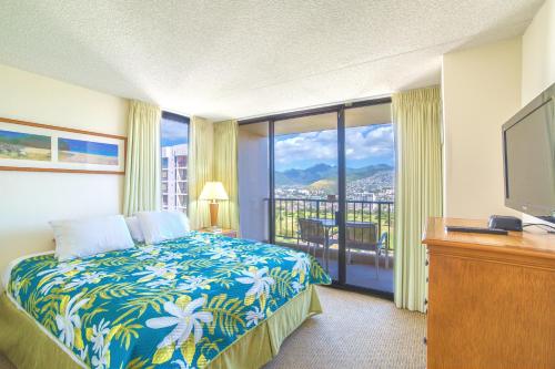 a hotel room with a bed and a television at Mountain View Condo, Near Beach, Free Parking! in Honolulu