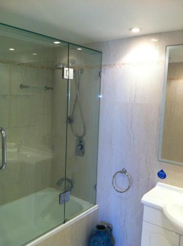 a bathroom with a shower and a tub and a sink at Carool Holiday Apartments in Gold Coast