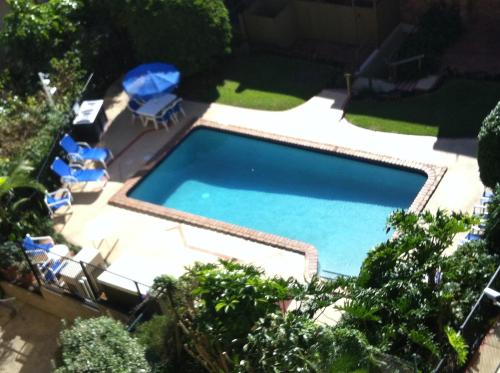 an overhead view of a swimming pool with chairs and umbrellas at Carool Holiday Apartments in Gold Coast