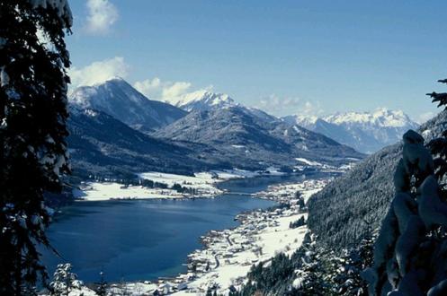 a view of a lake with snow covered mountains at Landhaus Sonneck in Weissensee