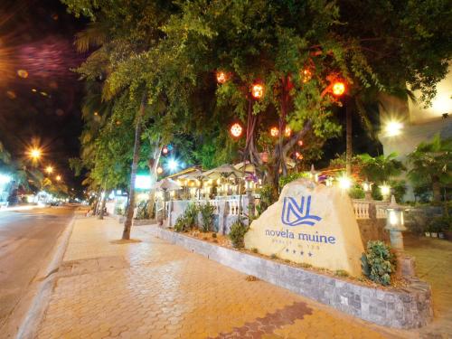 a sign for the nvidia mario minuto on a street at night at Novela Muine Resort & Spa in Mui Ne