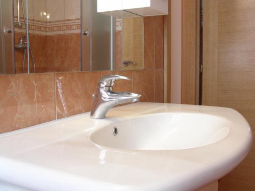 a white bathroom sink with a chrome faucet at Split Artistic Apartments in Split