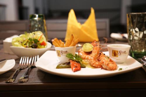 a plate of food with shrimp and french fries on a table at Serendib Signature Resort in Digana