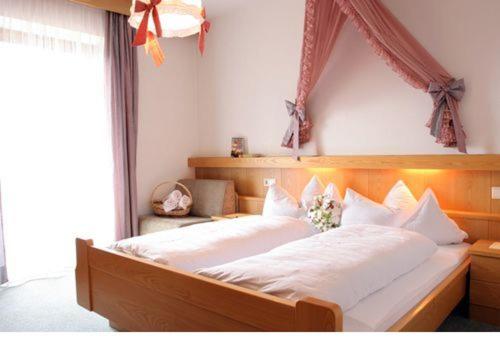 ヴァレスにあるResidence Grünwaldのベッドルーム1室(大型ベッド1台、木製ヘッドボード付)