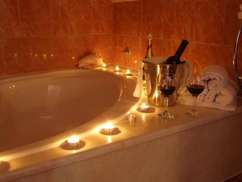 a bath tub with candles and wine glasses on it at Split Artistic Apartments in Split