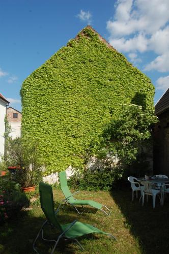 a large ivy covered building with chairs and a table at Hofgassl Zentgraf in Mörbisch am See