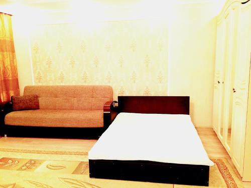 a living room with a bed and a couch at Vremena Goda Apartment in Astana in Astana