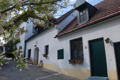 a white house with a green door and windows at Hofgassl Zentgraf in Mörbisch am See