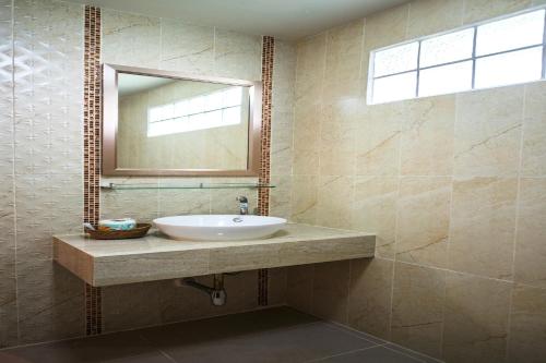 een badkamer met een wastafel en een spiegel bij Viking Resorts in Pattaya