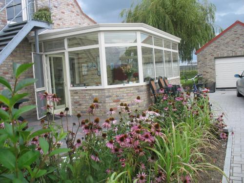 a glass house with flowers in the yard at B&B Greenhouse 37 in Langemark