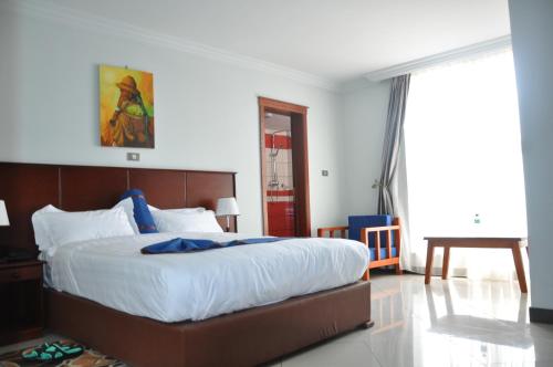 a bedroom with a large bed with white sheets at Kersay Hotel in Addis Ababa