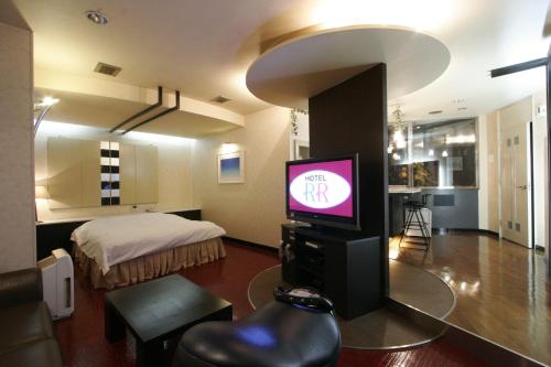 Hotel RR (Adult Only) في يوكايتشي: غرفة معيشة مع تلفزيون وسرير