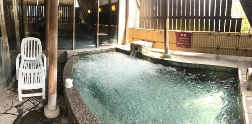 a swimming pool with a chair next to a building at The Bed and Spa (male only) in Tokorozawa