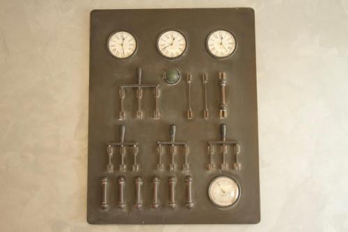 a wall mounted clock with four clocks on it at Hotel Miramonti in Schio