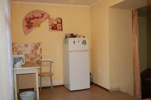 a kitchen with a white refrigerator and a table at Apartment on Stepana Bandery 37 Постійне електропостачання in Lviv
