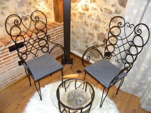 two chairs and a table in a room at Posada Los Templarios in Ucero