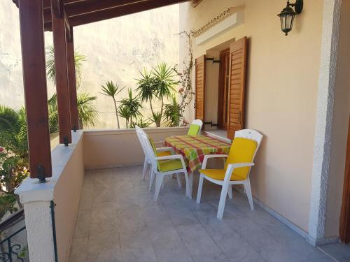 a patio with a table and chairs on a balcony at Nineta's House Sea View near the Airport in Artemida