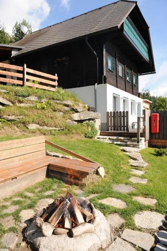 a fire pit in the grass in front of a building at Glühwürmchenhütte in Ratten