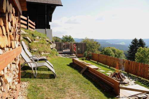 a yard with two benches and a fence at Glühwürmchenhütte in Ratten