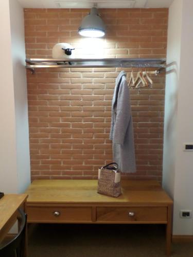 a room with a wooden table and a brick wall at Hotel Miramonti in Schio