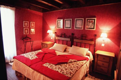 a red bedroom with a large bed with red walls at Hotel Pradas Ordesa in Broto