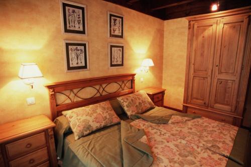 a bedroom with a bed and two night stands and two lamps at Hotel Pradas Ordesa in Broto
