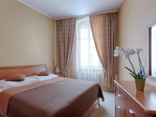 Un dormitorio con una cama y una ventana grande. en Rezidence Sadová, en Karlovy Vary