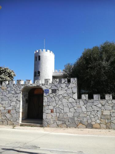 a stone wall with a tower on top of it at Castle By The Sea in Artemida