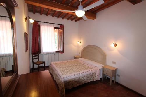CollemezzanoにあるAppartamenti Brunettiのベッドルーム1室(ベッド1台、シーリングファン付)