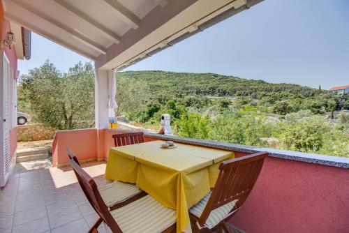 a table and chairs on a balcony with a view at House Dorita in Miholašćica