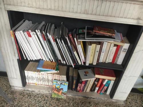 a book shelf filled with lots of books at Due Papi in Savona