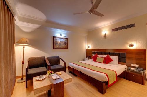a hotel room with a bed and a chair at Hotel Combermere in Shimla