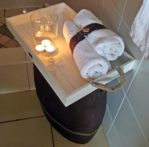 a nightstand with towels and candles in a bathroom at Small House Postup in Orebić