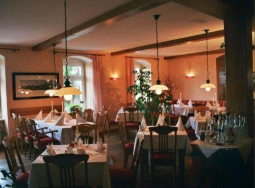 ein Restaurant mit Tischen und Stühlen sowie weißen Tischdecken in der Unterkunft Landhaus Heidehof in Dippoldiswalde