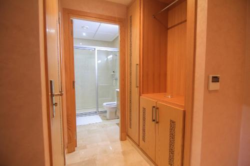 ein Bad mit einer Dusche, einem WC und einer Tür in der Unterkunft Hotel Kenzo in Safi