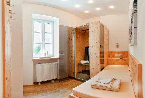 a room with a bed and a window at Hotel Garni Mühlbacher - inklusive kostenfreiem Eintritt in die Alpentherme in Bad Hofgastein