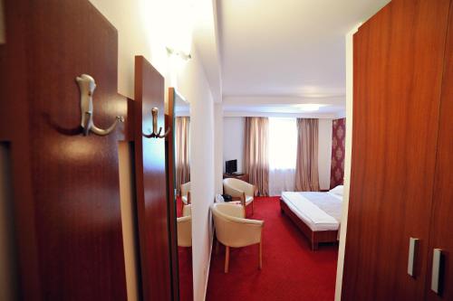 a hotel room with a bed and a bedroom at Hotel Roberto Slanic Prahova in Slănic