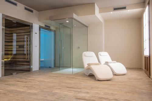 two white chairs in a room with a glass door at Il Feudo Di Agnadello in Agnadello