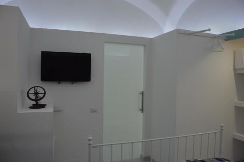 a flat screen tv on a white wall at Costantino Home in Pompei