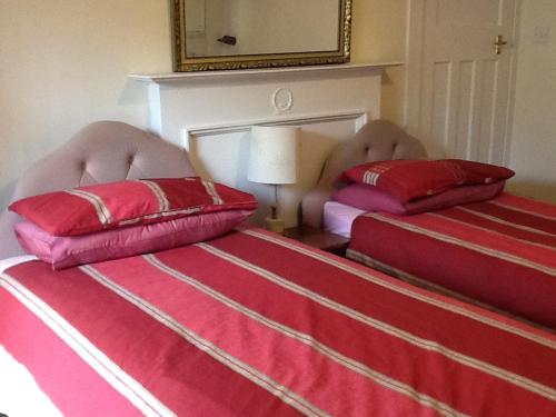 two beds with pillows on them in a bedroom at Rutland cottage in Largs